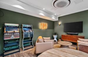 a living room with two pinball machines and a tv at The Parade - Cardiff - 10 Min Walk to City Centre in Cardiff
