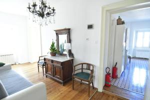 a living room with a couch and a table and a mirror at Panorama in Aurisina