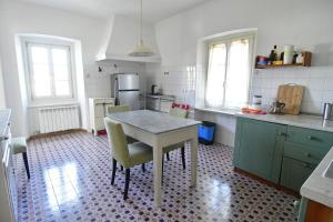 a kitchen with a table and some chairs in it at Panorama in Aurisina +16 photos