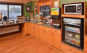 a kitchen with a refrigerator and a microwave at AmericInn by Wyndham Fergus Falls Conference Center in Fergus Falls