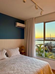 a bedroom with a bed and a large window at Casa Veleiro in Florianópolis