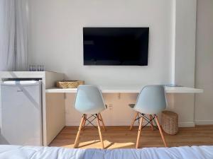 two chairs sitting next to a desk with a tv at Casa Veleiro in Florianópolis +29 photos