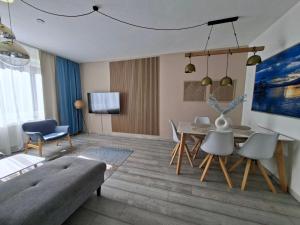 a living room with a couch and a table and chairs at La Vida appartment 1 in Klagenfurt