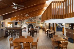 a restaurant with wooden tables and chairs and a fireplace at AmericInn by Wyndham Tofte Near Lake Superior in Tofte