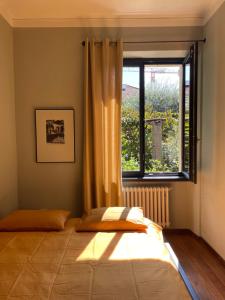 a bedroom with a bed and a large window at Casa d'epoca con giardino 5 min da Locarno in Minusio +24 photos