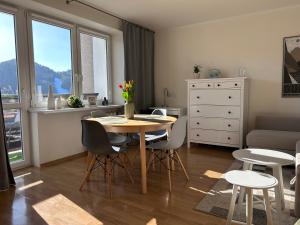 a kitchen and living room with a table and chairs at Apartament Babie Lato in Szczawnica