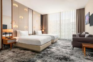 a hotel room with two beds and a couch at Tryp by Wyndham Istanbul Topkapi in Istanbul +54 photos