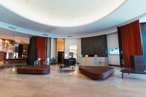 a lobby with two brown leather furniture in a building at Esplendor by Wyndham Mendoza in Mendoza