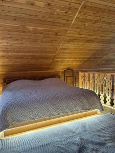 a bed in a room with a wooden ceiling at Garnu Maran in Garni