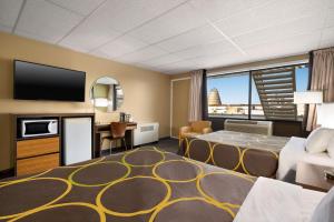 a hotel room with a bed and a flat screen tv at Super 8 by Wyndham Hearst ON in Hearst