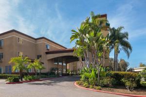a building with palm trees in front of it at Ramada Suites by Wyndham San Diego Hotel Circle Area in San Diego