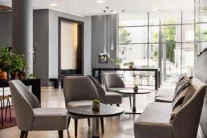 a living room with chairs and tables and windows at Vienna House by Wyndham Andel's Cracow in Krakow