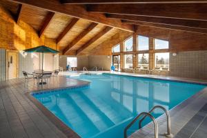a large swimming pool with chairs and a table at AmericInn by Wyndham Tofte Near Lake Superior in Tofte