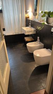 a bathroom with two sinks and two toilets at Casa d'epoca con giardino 5 min da Locarno in Minusio