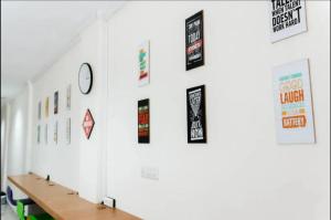 a hallway with a table and posters on the wall at Mutiara Kostel at Batuceper in Poris-lor
