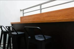 two black chairs sitting next to a wooden shelf at Mutiara Kostel at Batuceper in Poris-lor