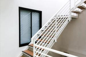 a white staircase with a window at Mutiara Kostel at Batuceper in Poris-lor