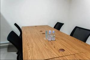 a wooden table with four drinking bottles on it at Mutiara Kostel at Batuceper in Poris-lor
