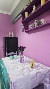a purple room with a table with a vase of flowers at Mermaid house in Drama