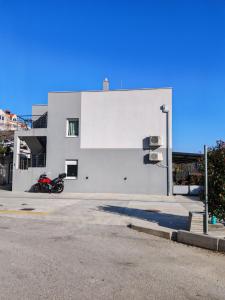 a motorcycle parked in front of a white building at Apartment Rita in Mokošica