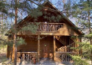 a log cabin in the woods with a deck at Lisotel in Rokytne