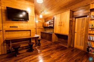 a wooden room with a table and a tv on the wall at Hotel Narangala Wooden Villa in Badulla
