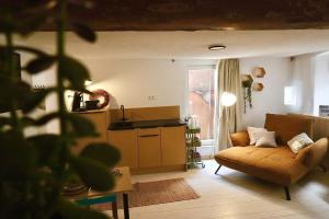 a living room with a couch and a kitchen at Klinkerstube in Heuchelheim-Klingen