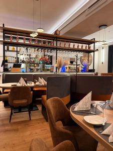 a restaurant with tables and chairs and a bar at Hotel Stadt Emmerich in Emmerich