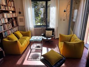 a living room with two yellow couches and a table at Casa d'epoca con giardino 5 min da Locarno in Minusio