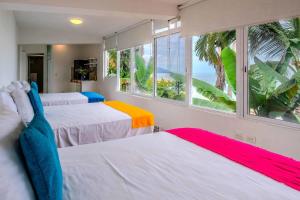 two beds in a room with a view of the ocean at Ocean Front Villa - Private Pool and Ocean Access in Puerto Vallarta