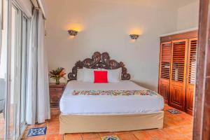 a bedroom with a large bed with a red pillow at Ocean Front Villa - Private Pool and Ocean Access in Puerto Vallarta