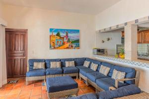 a living room with a blue couch and chairs at Ocean Front Villa - Private Pool and Ocean Access in Puerto Vallarta +12 photos