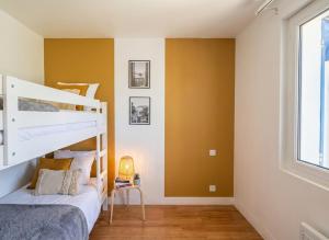 a bedroom with yellow walls and a bunk bed at Maison plain pied hyper centre avec véranda 5 min à pied plage Royan 3 chambres in Royan