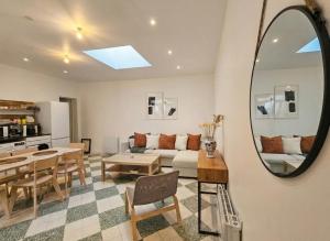 a living room with a couch and a table and a mirror at Maison plain pied hyper centre avec véranda 5 min à pied plage Royan 3 chambres in Royan