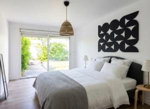 a bedroom with a bed and a large window at Maison plain pied hyper centre avec véranda 5 min à pied plage Royan 3 chambres in Royan +1 photo