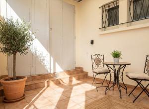 a room with a table and chairs and a potted plant at Maison plain pied hyper centre avec véranda 5 min à pied plage Royan 3 chambres in Royan