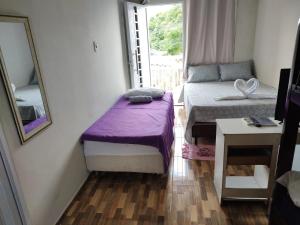 a small room with a bed and a mirror at Pousada Riocabana in Barreirinhas