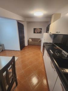 a kitchen with a stove and a couch in a room at Apartment 3 by Villa Ceni in Elbasan +7 photos