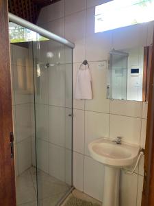 a bathroom with a sink and a glass shower at Chalé Ametista in Ouro Preto