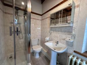 a bathroom with a toilet and a sink and a shower at Chambre dans un Moulin in Rouy