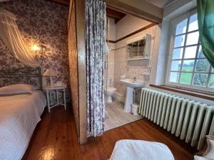 a bedroom with a bed and a sink and a window at Chambre dans un Moulin in Rouy