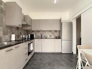 a kitchen with white cabinets and a white refrigerator at Zinas modern flat Nicosia in Strovolos