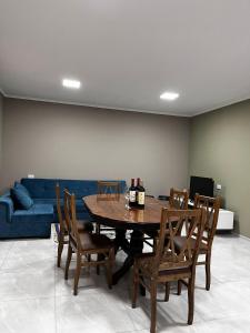 a dining room with a table and chairs and a blue couch at Rachnari Guest House in Gari