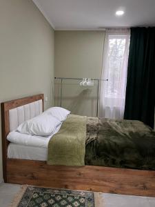 a bedroom with a wooden bed with a window at Rachnari Guest House in Gari +1 photo