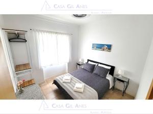 a small bedroom with a bed and a window at Casa Gil Anes in Almada