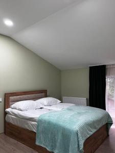 a bedroom with a bed with a green blanket on it at Rachnari Guest House in Gari