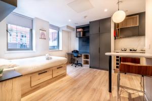a bedroom with a large bed and a kitchen at Stylish & Spacious Studio - Prime Briggate Location -Walk Everywhere in Leeds +36 photos