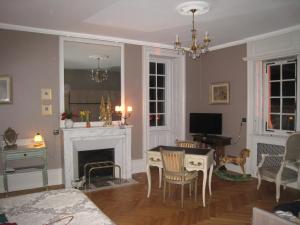 a living room with a table and a fireplace at Le BALCON DU PRINCE in Montbéliard