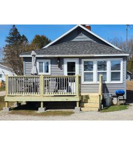 a small house with a porch and a deck at #7 Kipling Cottages Last Resort on Lake Michigan in Gladstone