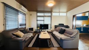 a living room with two leather couches and a television at SECONDHOUSE WINTER - Vacation STAY 24982v in Kita-hamachō